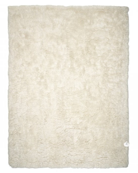 Rectangular off-white faux fur area rug with a plush, shaggy texture isolated on a white background.