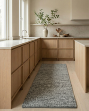 Grauer, rechteckiger Webteppich in moderner Küche mit hellen Eichenholzfronten und Arbeitsplatte.