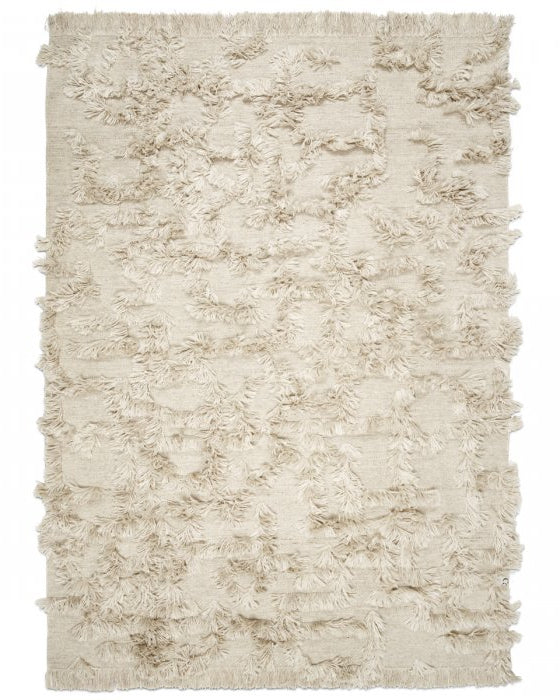 Beige rectangular rug with textured shaggy fringe pattern on a woven fabric base, featuring a minimalist bohemian style.