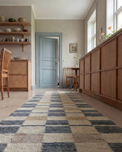 Läufer mit kariertem Muster in Beige, Grau und Blau in einem gemütlichen, skandinavisch eingerichteten Esszimmer.
