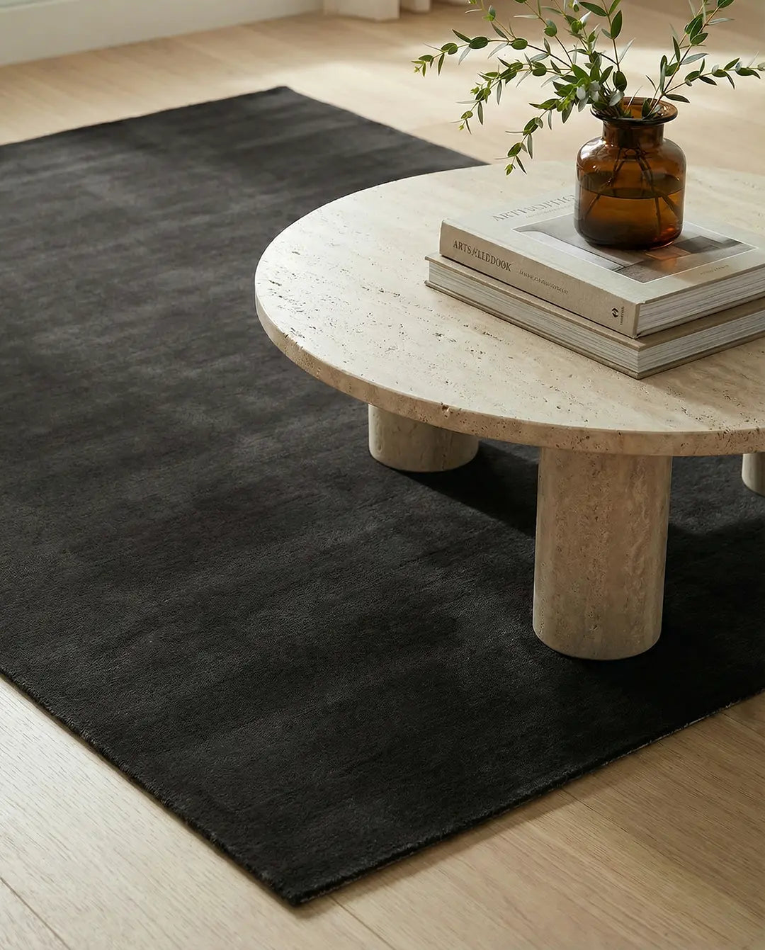 Mjuk, enfärgad mörkgrå matta i rektangulär form på ett ljust trägolv.