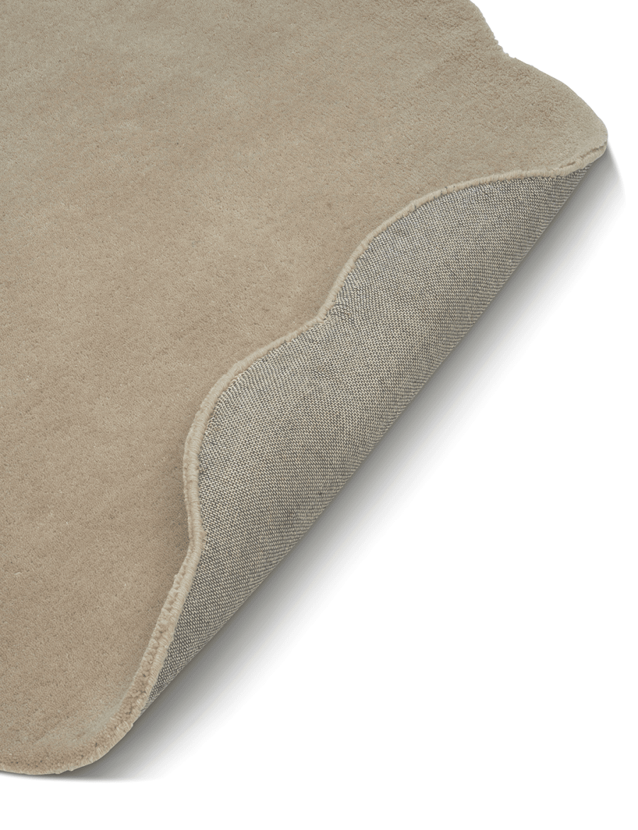 Beige Ullmatta Shell - För måttbeställning, frilagd mot vit bakgrund. Detaljbild av ett uppvikt hörn.