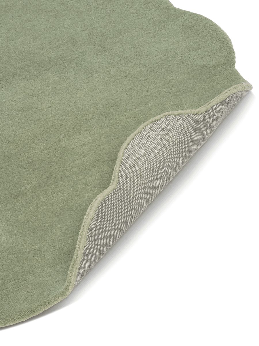 Grön Ullmatta Shell - För måttbeställning, frilagd mot vit bakgrund. Detaljbild av ett uppvikt hörn.