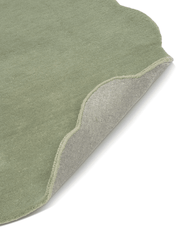 Grön Ullmatta Shell - För måttbeställning, frilagd mot vit bakgrund. Detaljbild av ett uppvikt hörn.