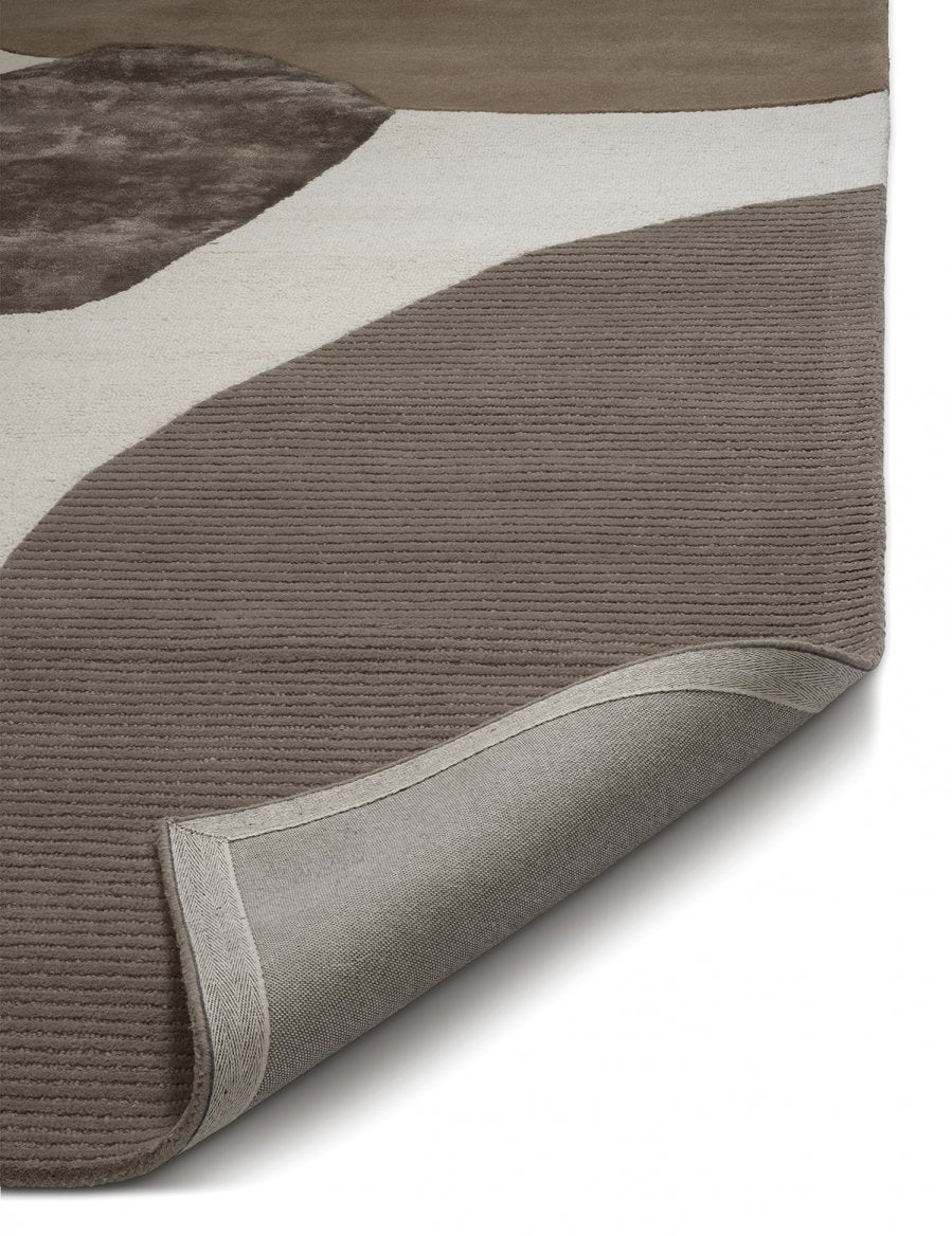 Abstract area rug featuring a modern taupe and cream color-block pattern with a high-low ribbed texture.