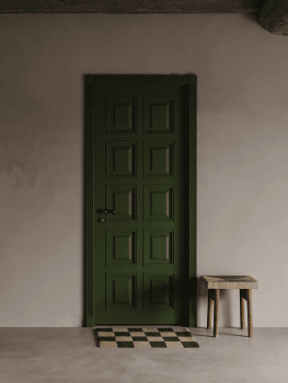 Dörrmatta Square Skogsgrön/Natur i handvävd ull framför grön dörr och vägg i neutral ton, med liten pall i trä och naturmaterial