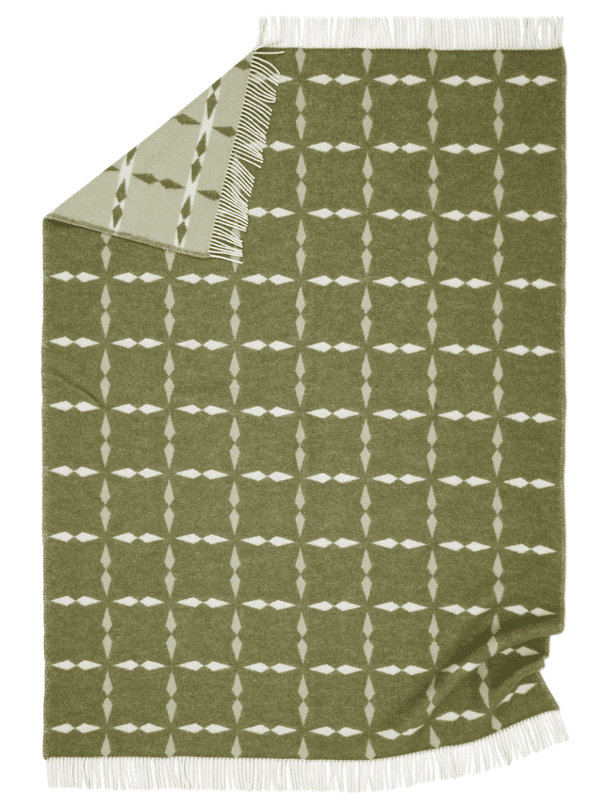 En ullpläd i samma grafiska, jacquardvävda mönster men i ljusare färgställning med vitt, beige och grått. Även denna pläd har fr